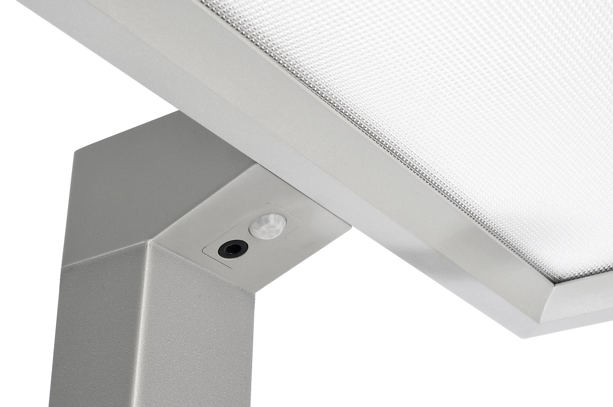Lampe med integreret bevægelsessensor og moderne, metallisk overflade, der vender opad mod lyskilden.