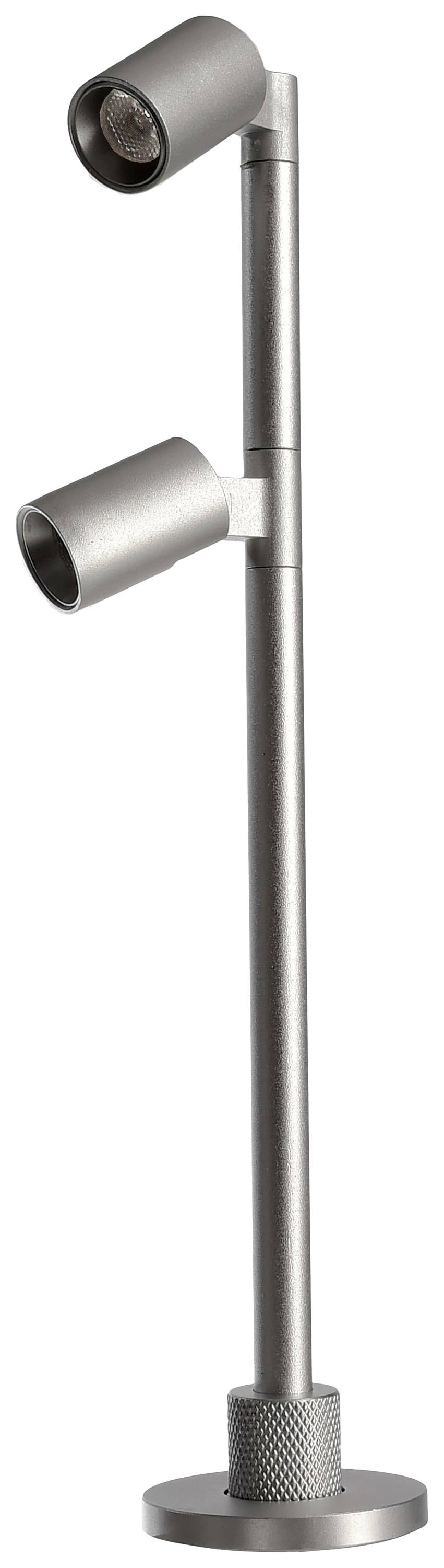 Sølvfarvet, moderne gulvlampe med to justerbare lampehoveder, velegnet til fokuseret belysning i indendørs rum.