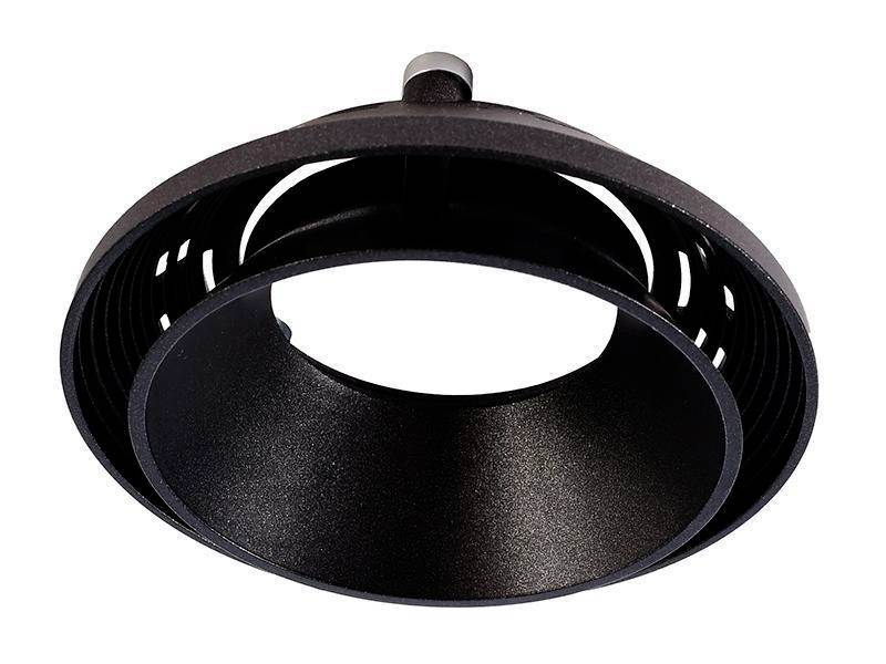 Et sort, cirkulært ventilationselement med lameller og en central fastgørelseskrue. Hovedkarakteristikken er den ringformede form.