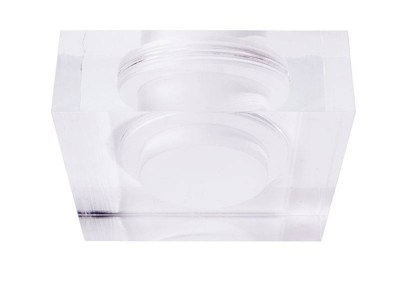 En klar, rektangulær, transparent akrylblok med et indlejret design, der skaber dekorative effekter ved lysets brydning.