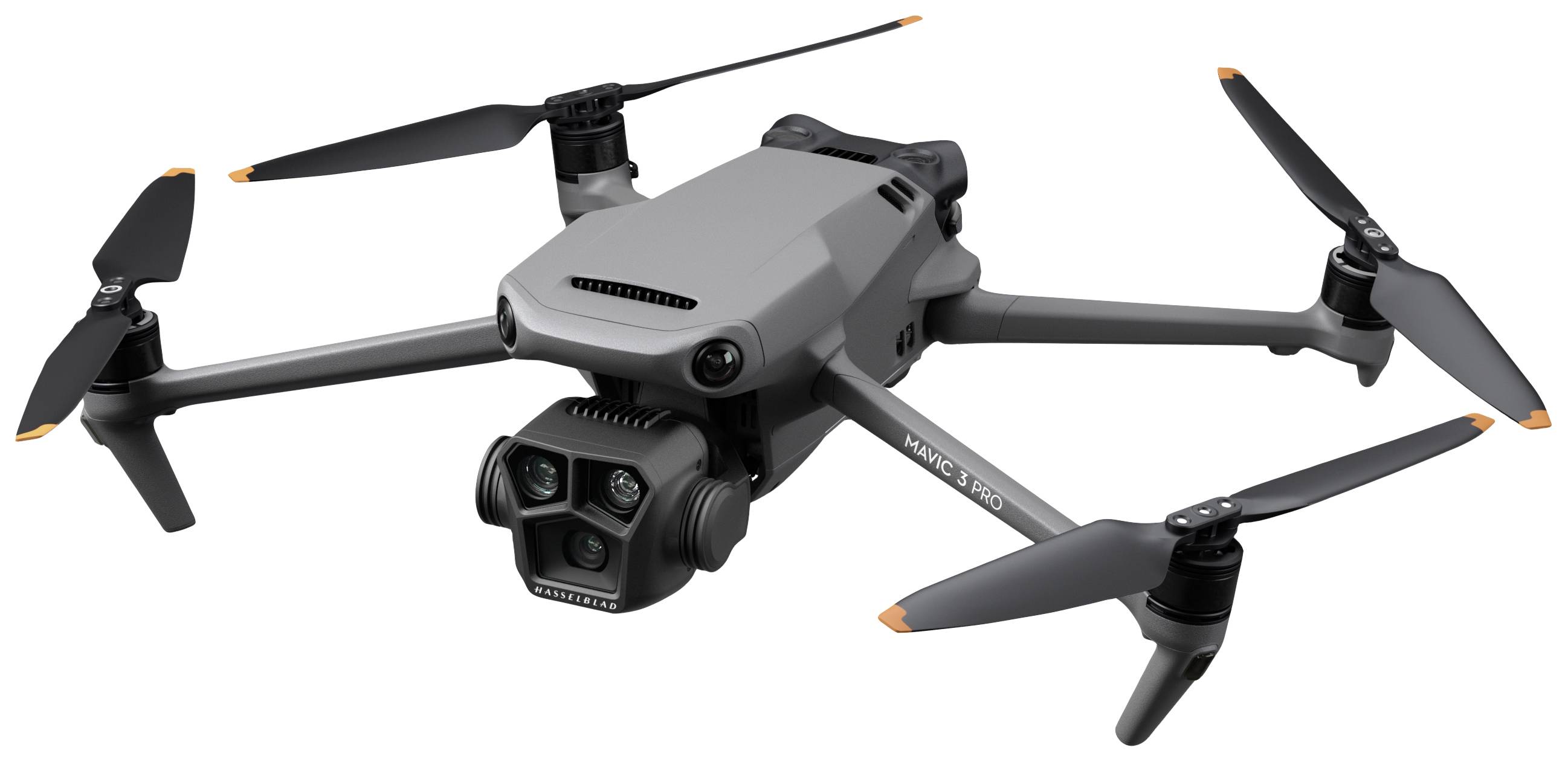 En grå drone med fire rotorer, udstyret med et kamera fortil, svæver i luften.