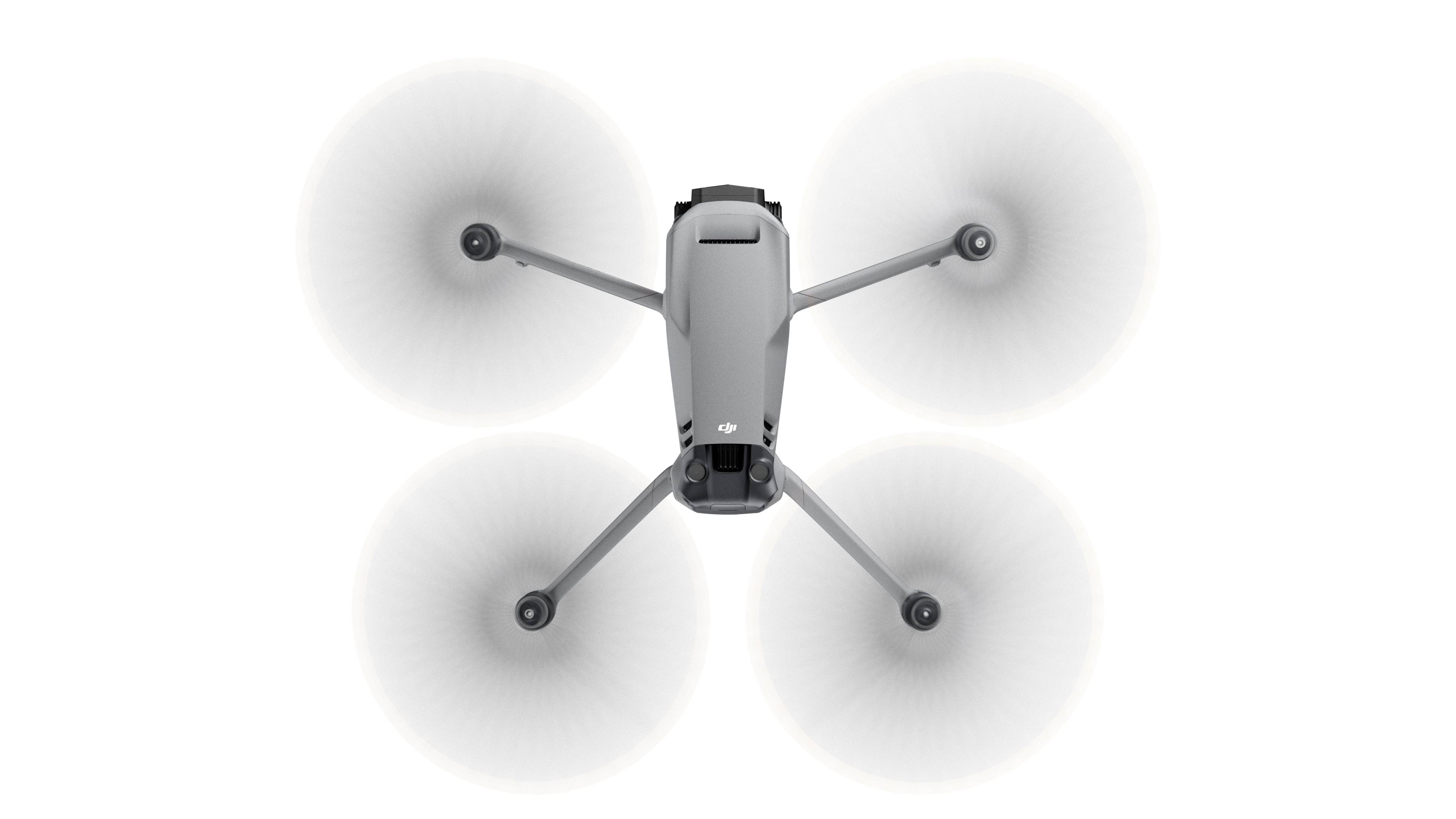 En grå drone med fire roterende propeller, vist fra oven på hvid baggrund.