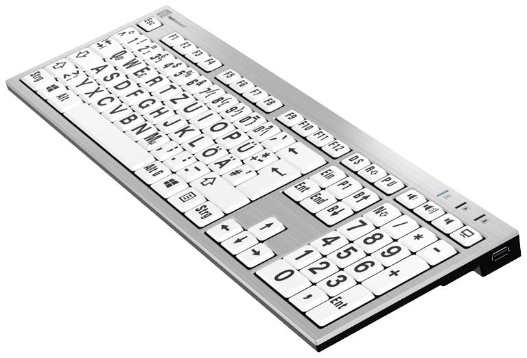 Sølvfarvet computertastatur med store, højkontraststående sorte bogstaver på hvide taster, som hjælper personer med synsnedsættelse.