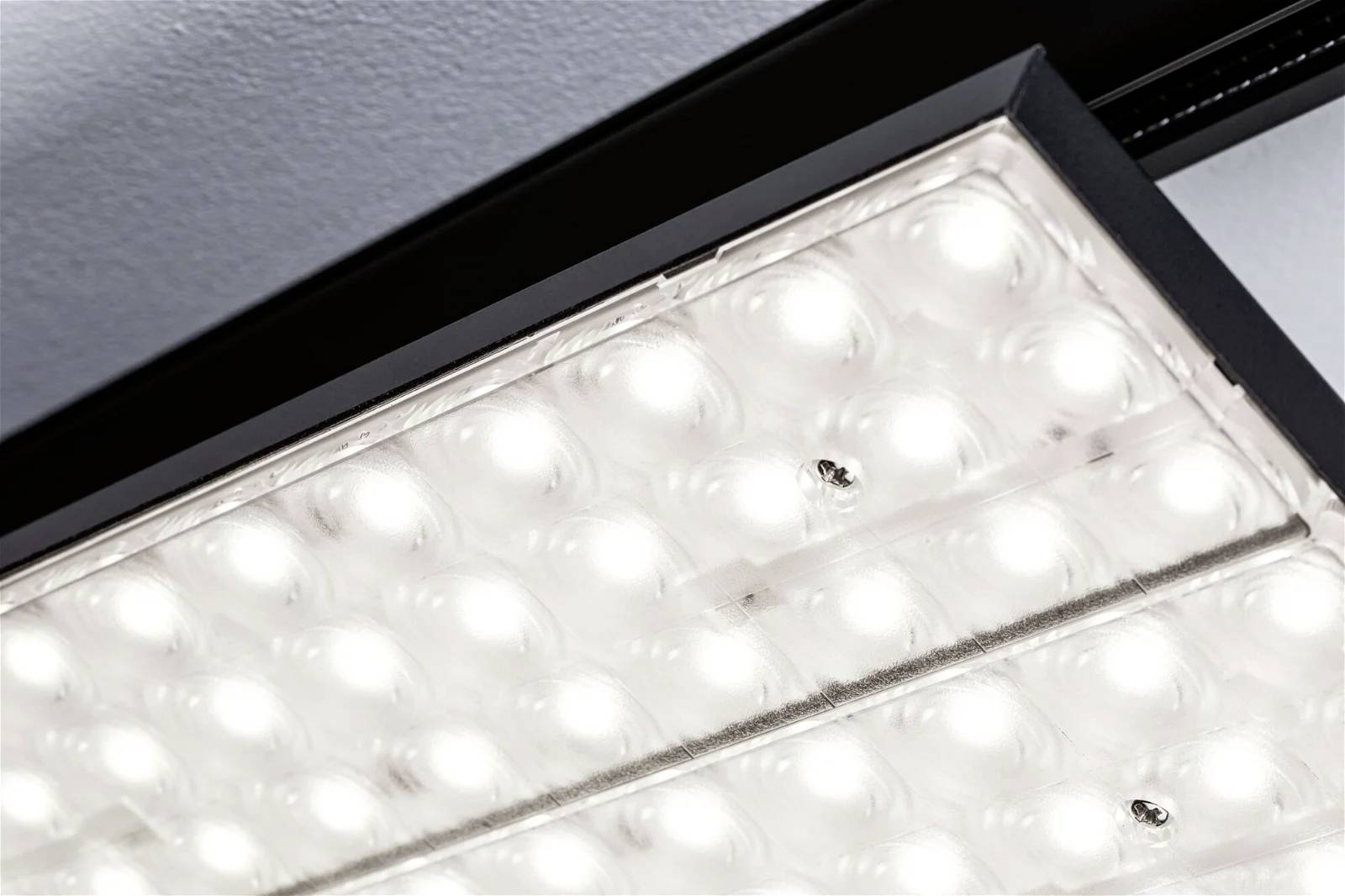 Et tændt LED-loftarmatur med mange små, runde lys, der udsender et klart, ensartet skær.