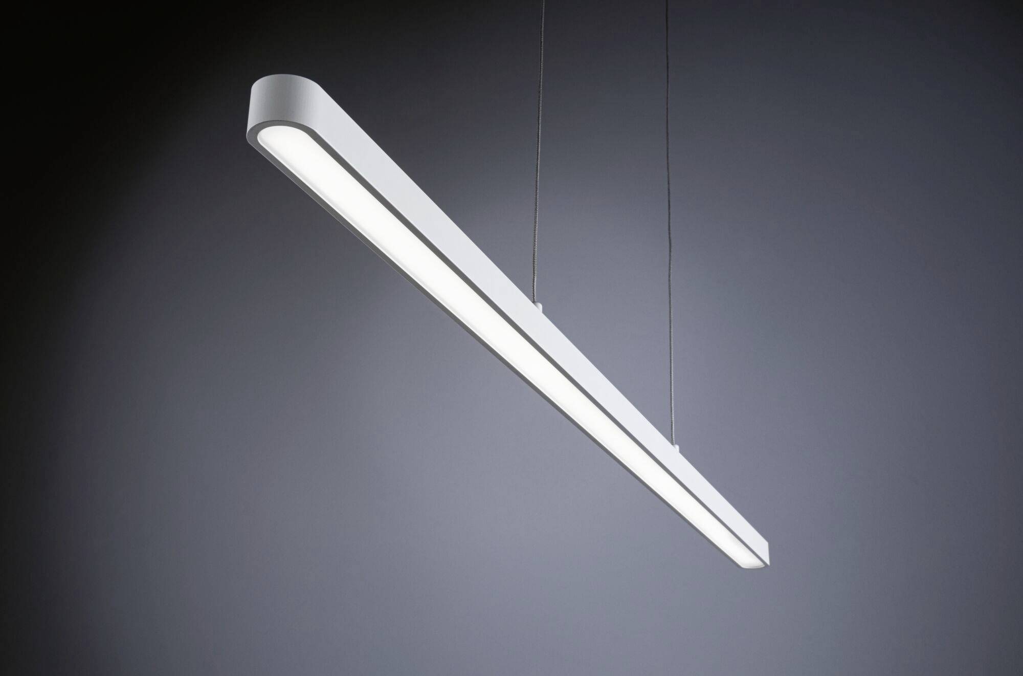 En moderne, aflang loftslampe med et slankt design, der hænger fra loftet ved hjælp af to kabler og udsender et klart, hvidt lys.
