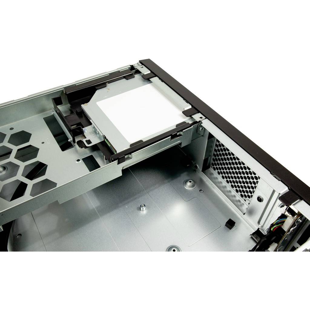 Et åbent computerkabinet viser indvendigt en tom disketteplads, ventilationsgitter og metalstivere.