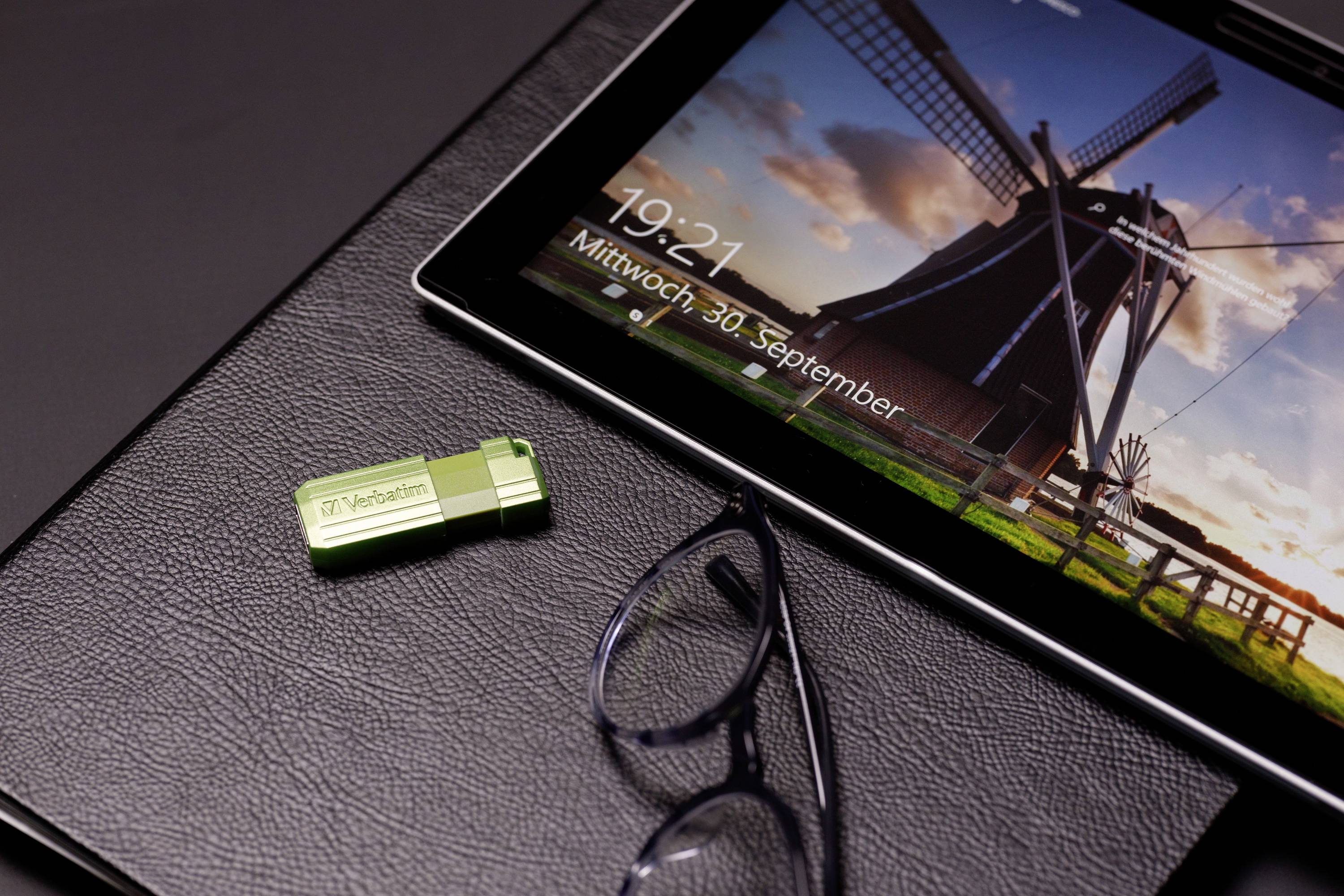 Laptop-skærmen viser en vindmølle og klokkeslættet 19:21 onsdag den 30. september. Ved siden af ligger en grøn USB-stick og et par briller.