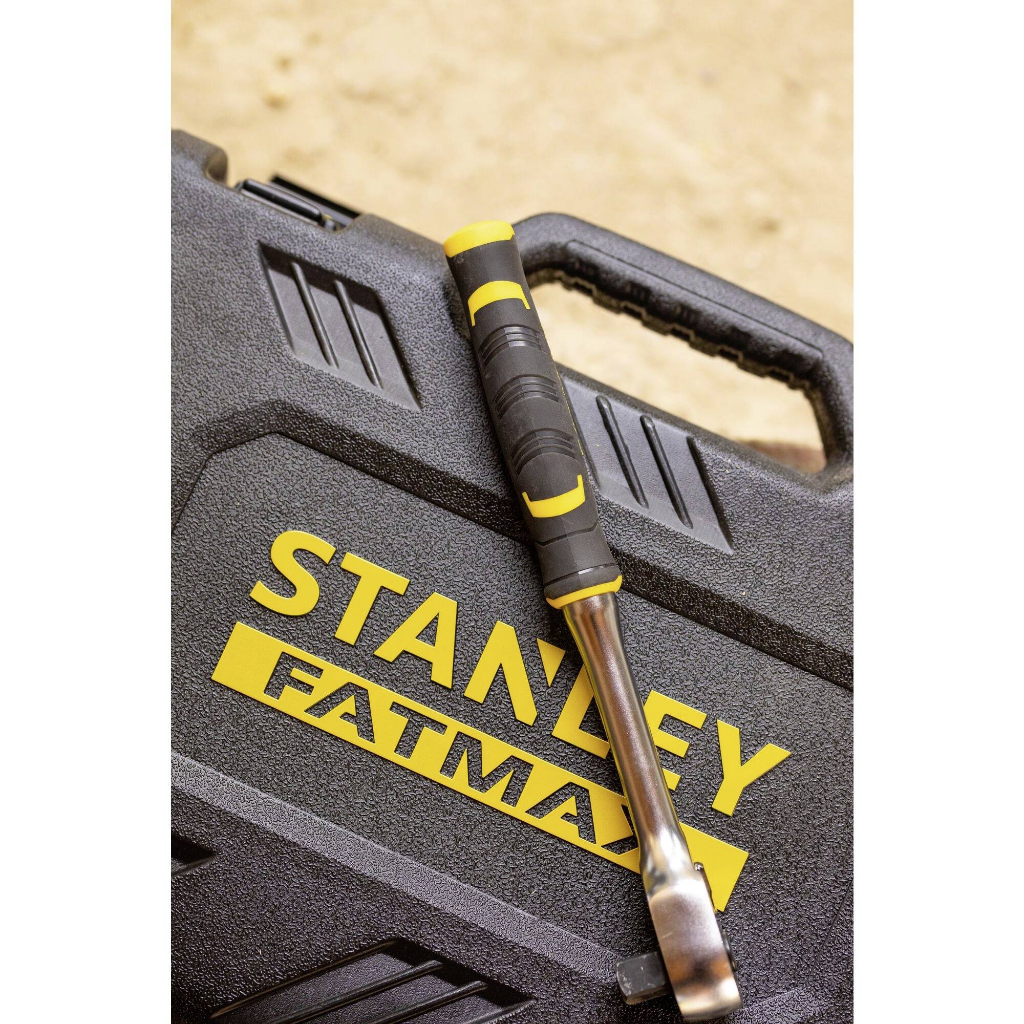 En Stanley FatMax mejsel ligger på en sort værktøjskasse med det gule Stanley FatMax-logo.