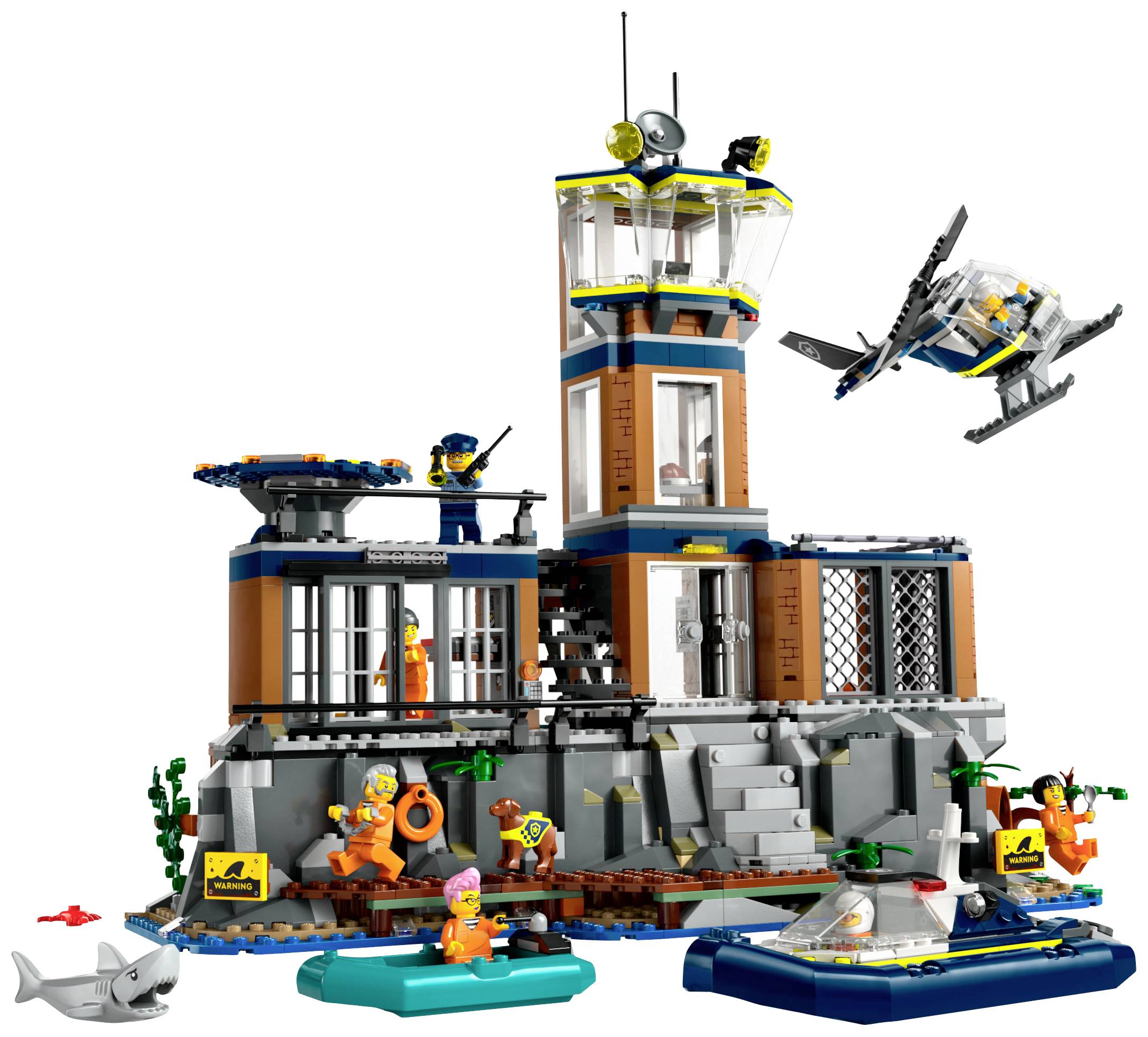 LEGO-sæt med kystvagtmotiv: et fyrtårn, helikopter, haj og flere figurer i redningsscener på et klippefyldt kystterræn.