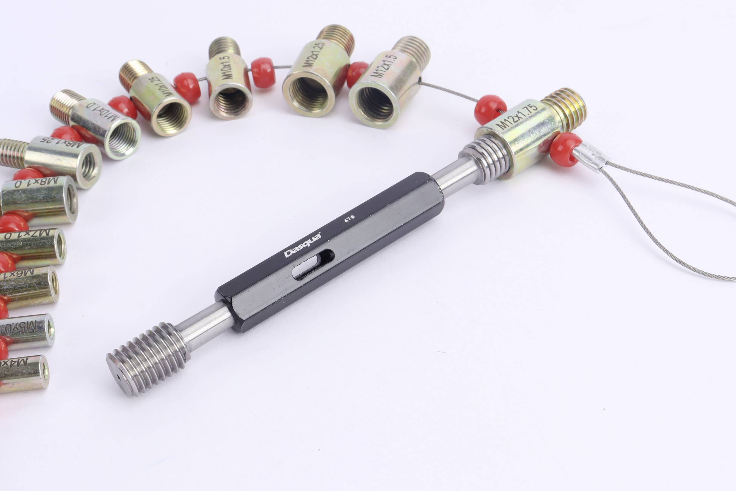 Flere gevindmålpinde i forskellige størrelser, arrangeret i en halvkreds, med en hovedpind i midten til måling.