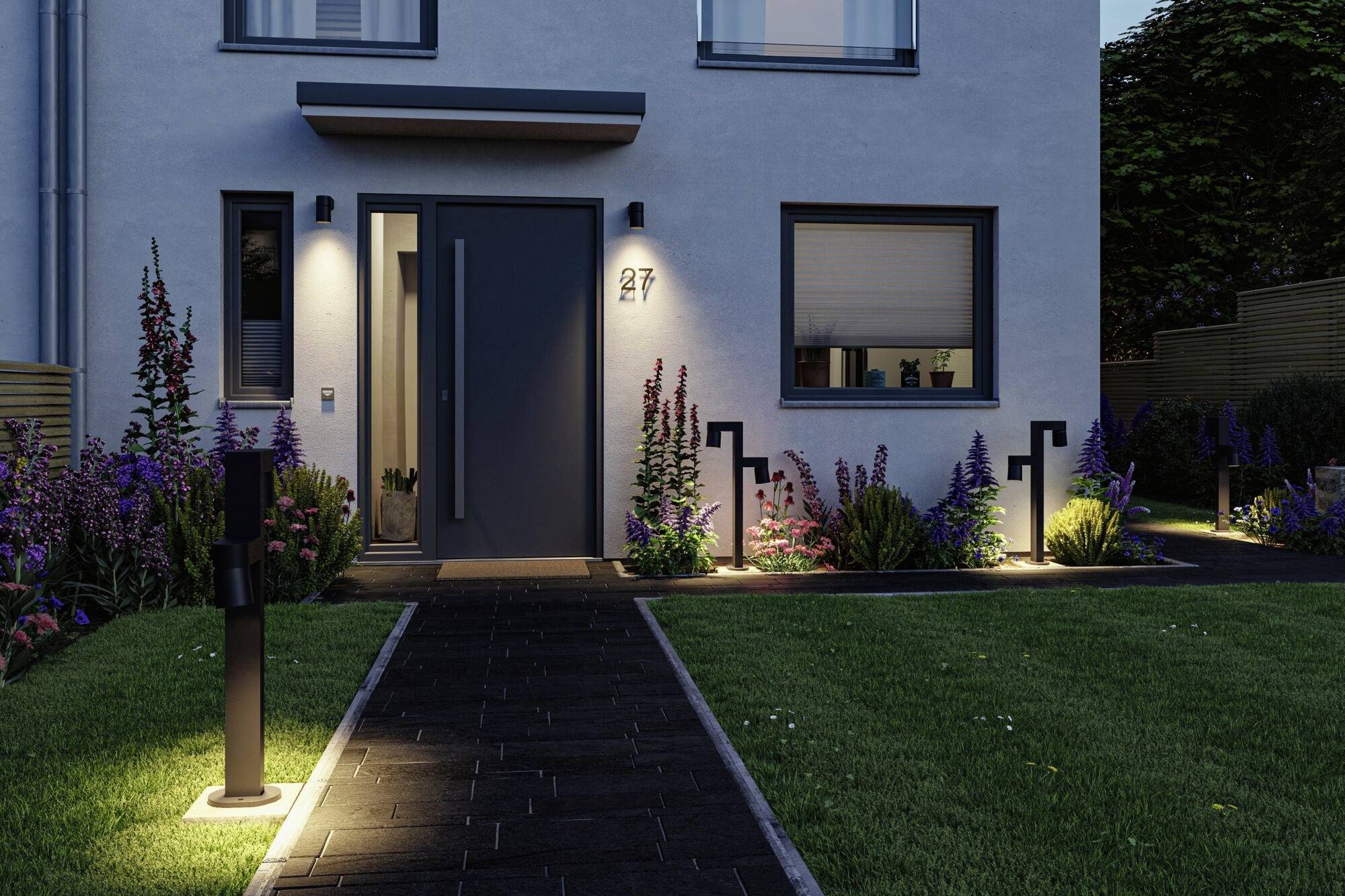 Et moderne hus ved aftenskumringen med oplyst indgang og velholdt forhave. Husnummer 27 er synligt.