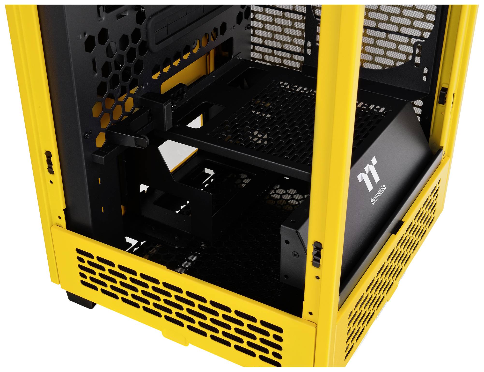 Et gult computerkabinet med sort gitterdesign, åbnet, viser dets indre. Rummer plads til komponenter og ventilation.