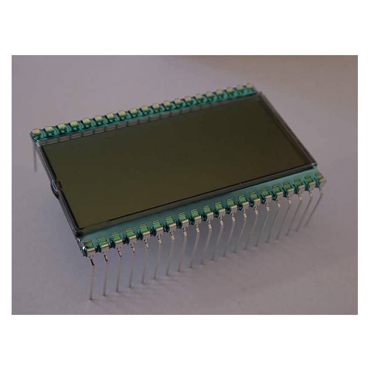 Et rektangulært elektronisk komponent med mange ben, sandsynligvis et display eller modul, ligger på en overflade.