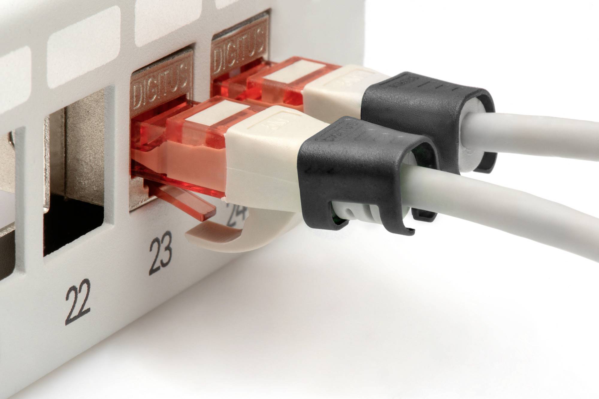 To netværkskabler er sat i port 23 og 24 på en Ethernet-switch. Kablerne har røde stik.