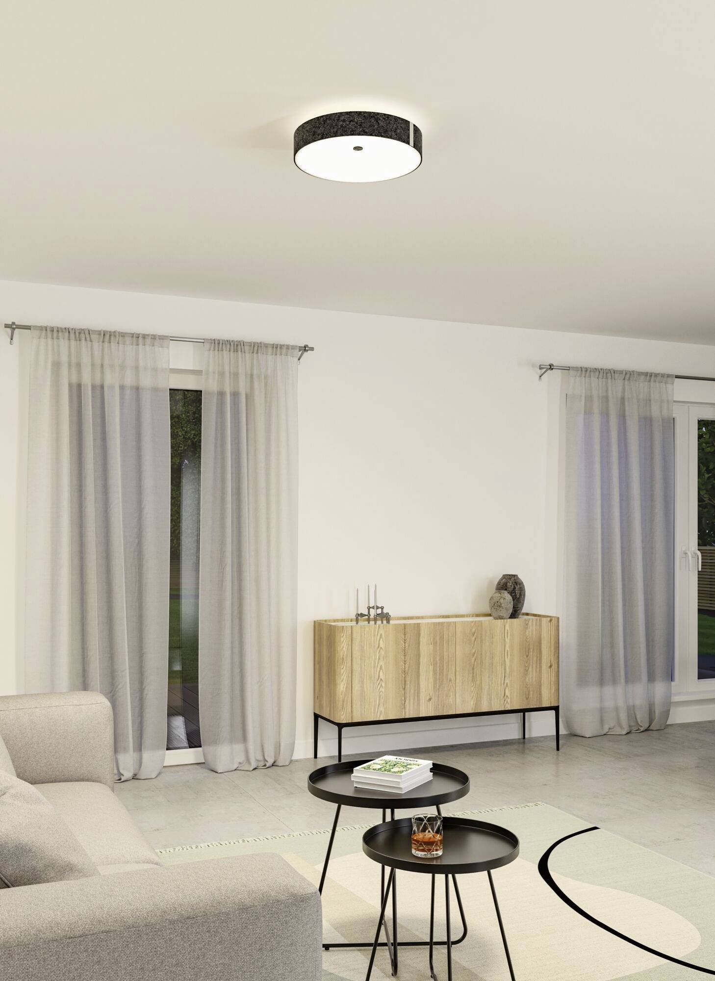 Stue med sofa, to rundborde, standerlampe, gardiner og kommode. Moderne loftbelysning.