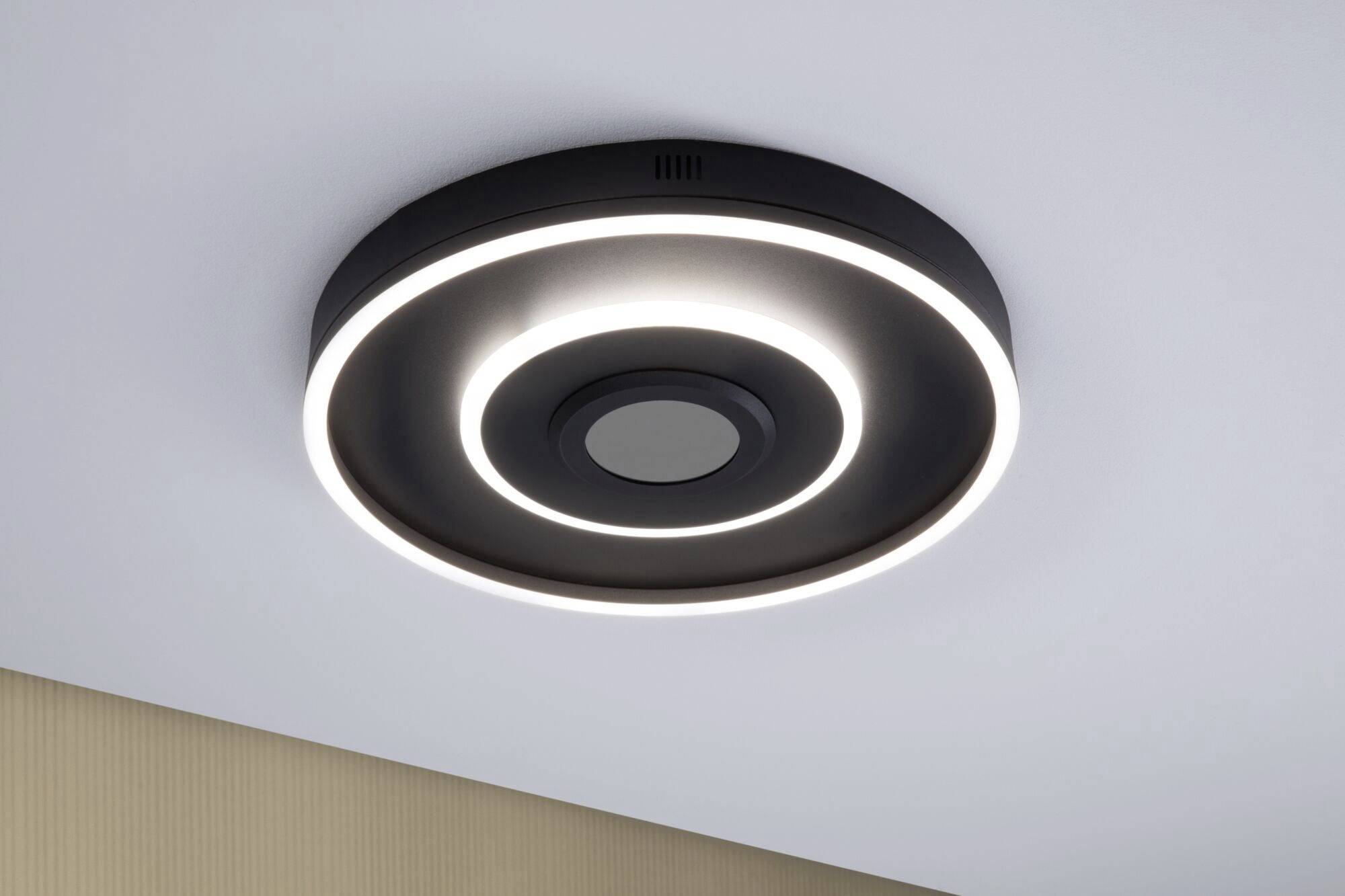Moderne loftlampe med sort ramme og lysende cirkler, monteret på en hvid lofteflade.