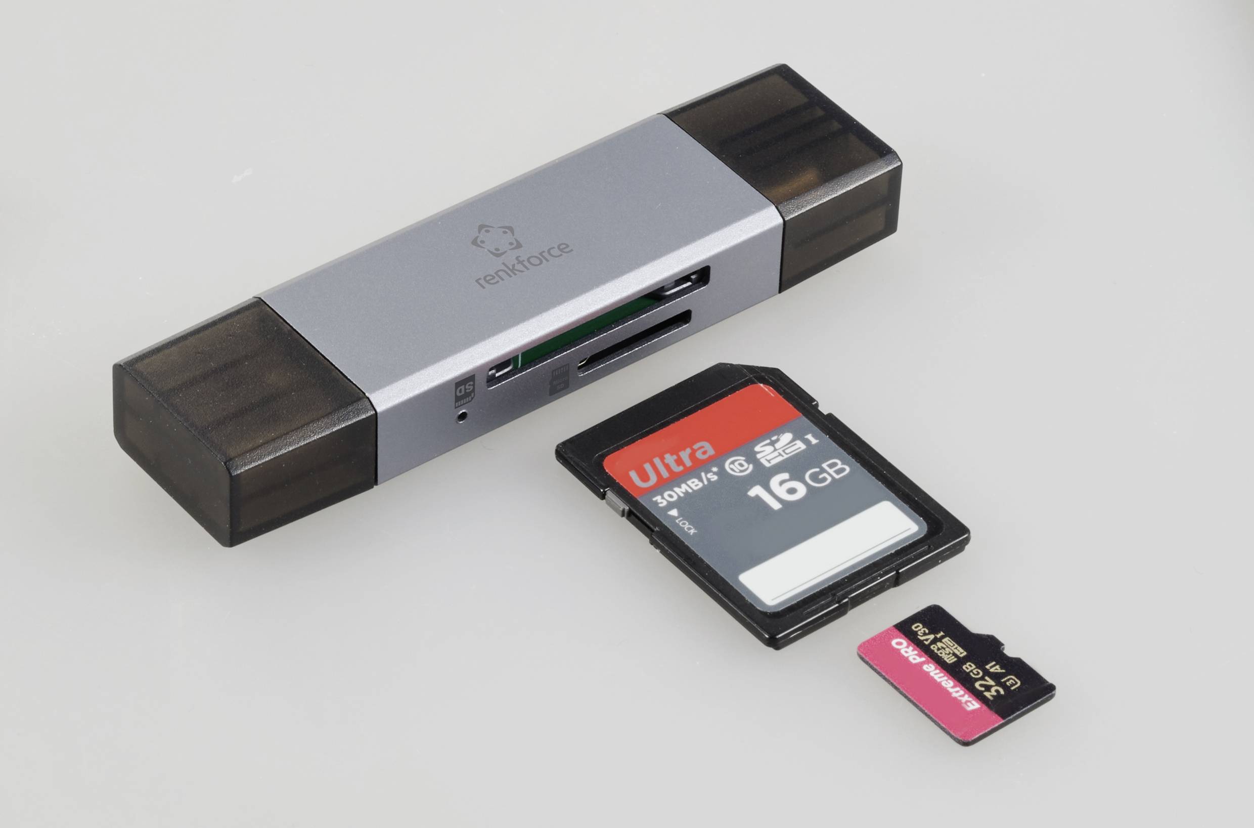 En USB-kortlæser med to SD-kort, hvoraf ét er på 16 GB og et mindre MicroSD-kort, ligger ved siden af.