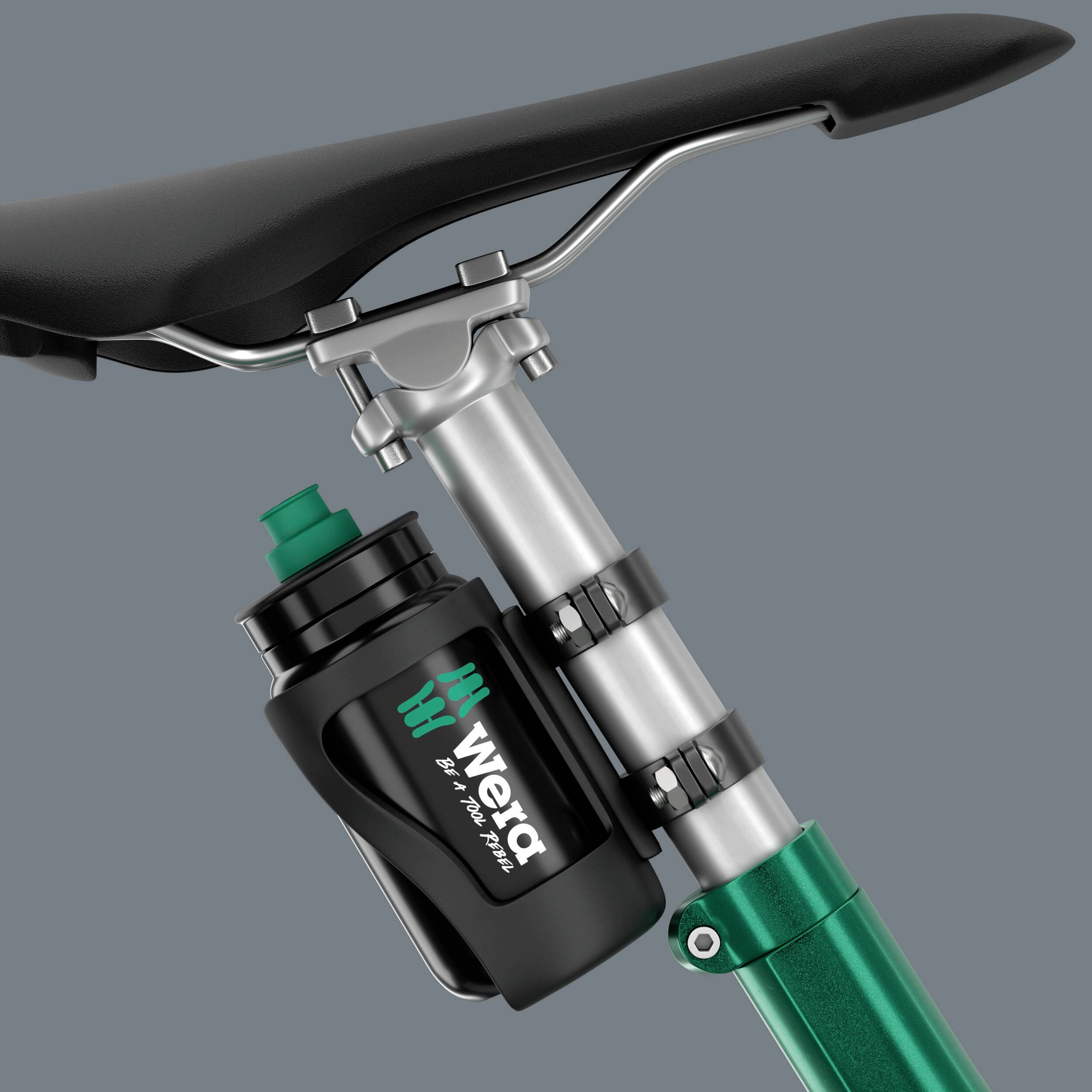 Cykelsadel med en lille værktøjstaske fastgjort på sadelrøret; tasken bærer logoet 'wexa'.