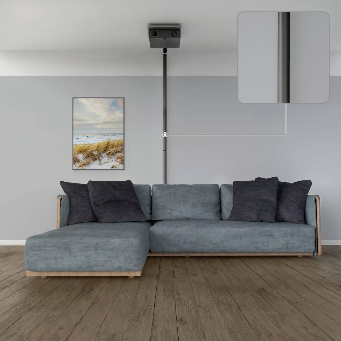 Et grå sofa med blå puder står på et trægulv. Over sofaen er en projektor monteret i loftet, ved siden af et billede af en strand.
