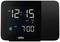 Elektronisk ur med sort kabinet, viser 12:15 AM. Alarm er indstillet til 7:00 AM.