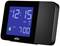 Sort digitalur med blå baggrundsbelyst display viser '12:15 AM'. Alarm indstillet til '7:00'.