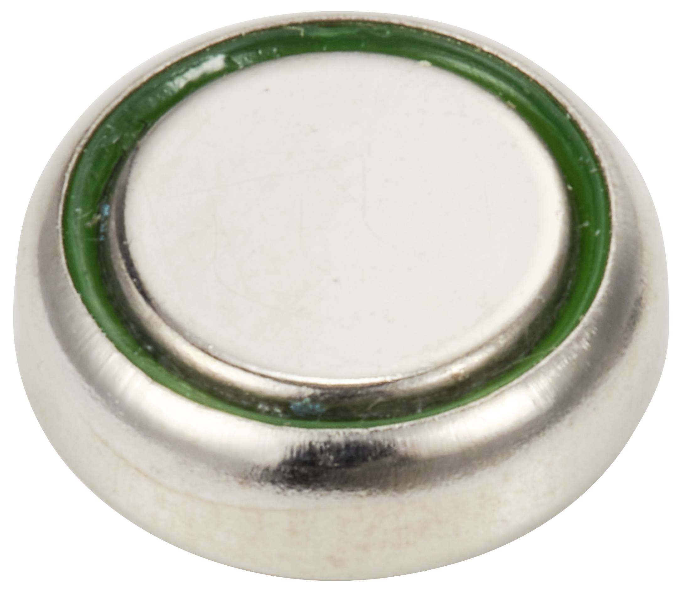En rund sølvfarvet magnet, omgivet af en grøn ring, ligger på en hvid overflade.