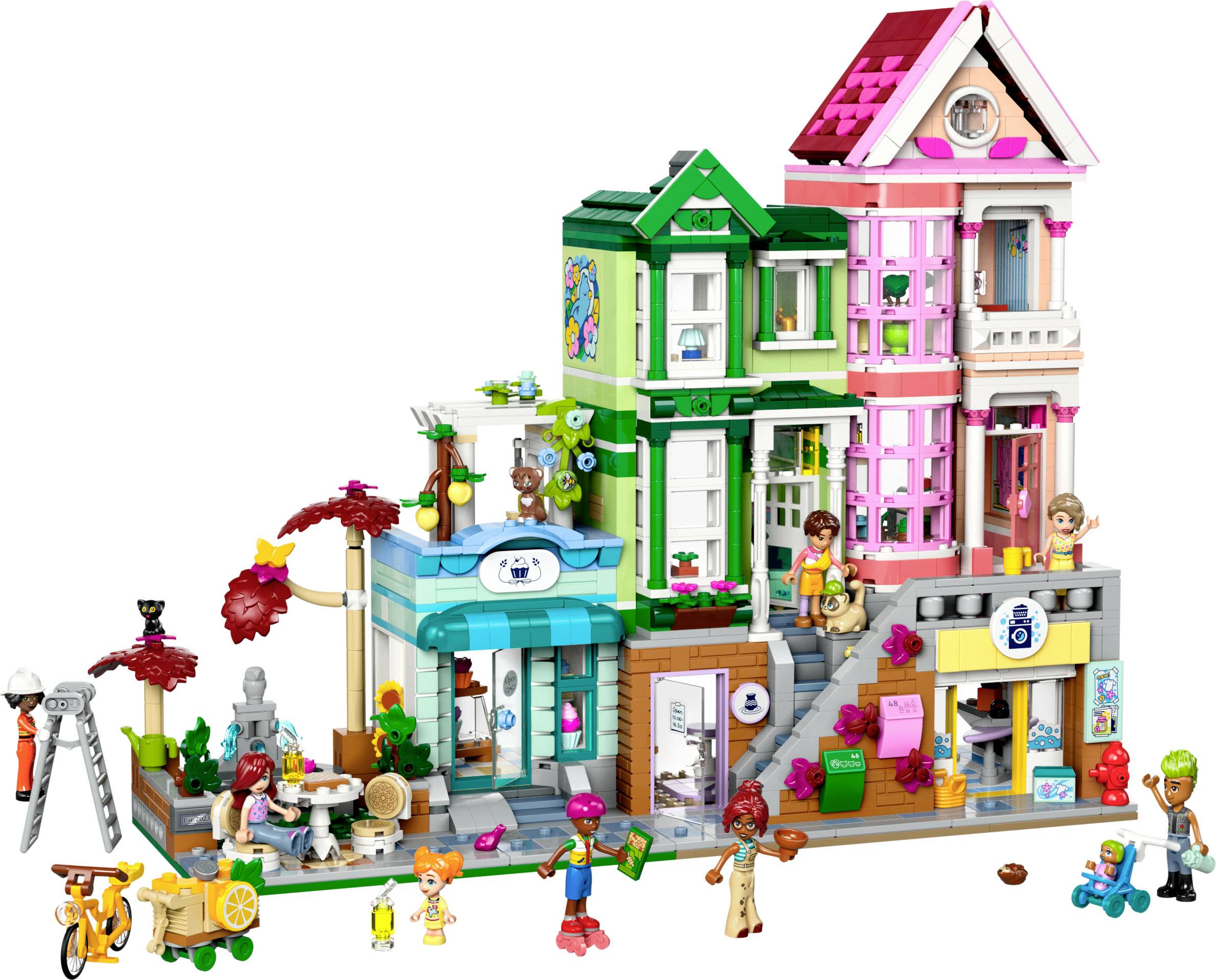 Lego-sæt med farverige bygninger, caféer, figurer og tilbehør som træer og en cykel. Scenen viser et travlt byliv.