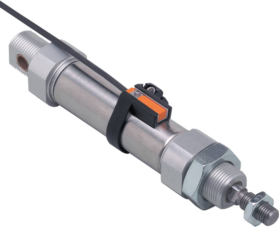 En cylindrisk metallisk sensor med et orangefarvet fastgørelseselement foran en sort baggrund.