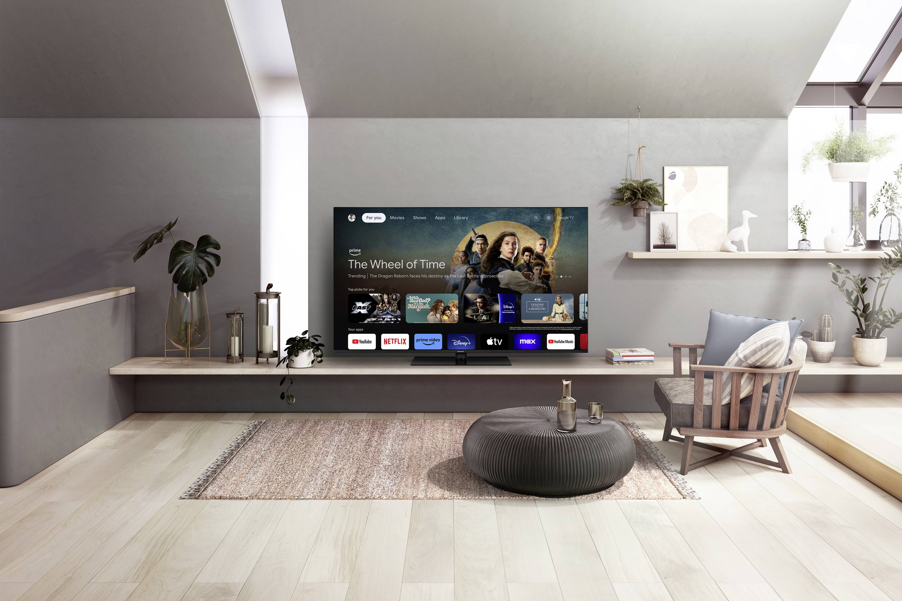 Moderne stue med stor fladskærms-tv på væggen. Fjernsynet viser streaming-tjenester som Netflix og Disney+. Elegant, minimalistisk design.