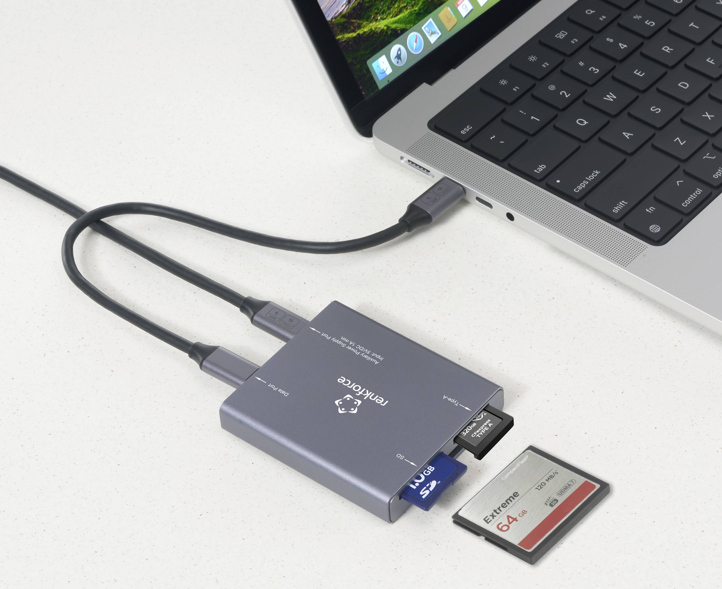 En bærbar computer er tilsluttet en USB-hub, hvor der er synlige flere hukommelseskort-slots og en tilsluttet USB-nøgle.