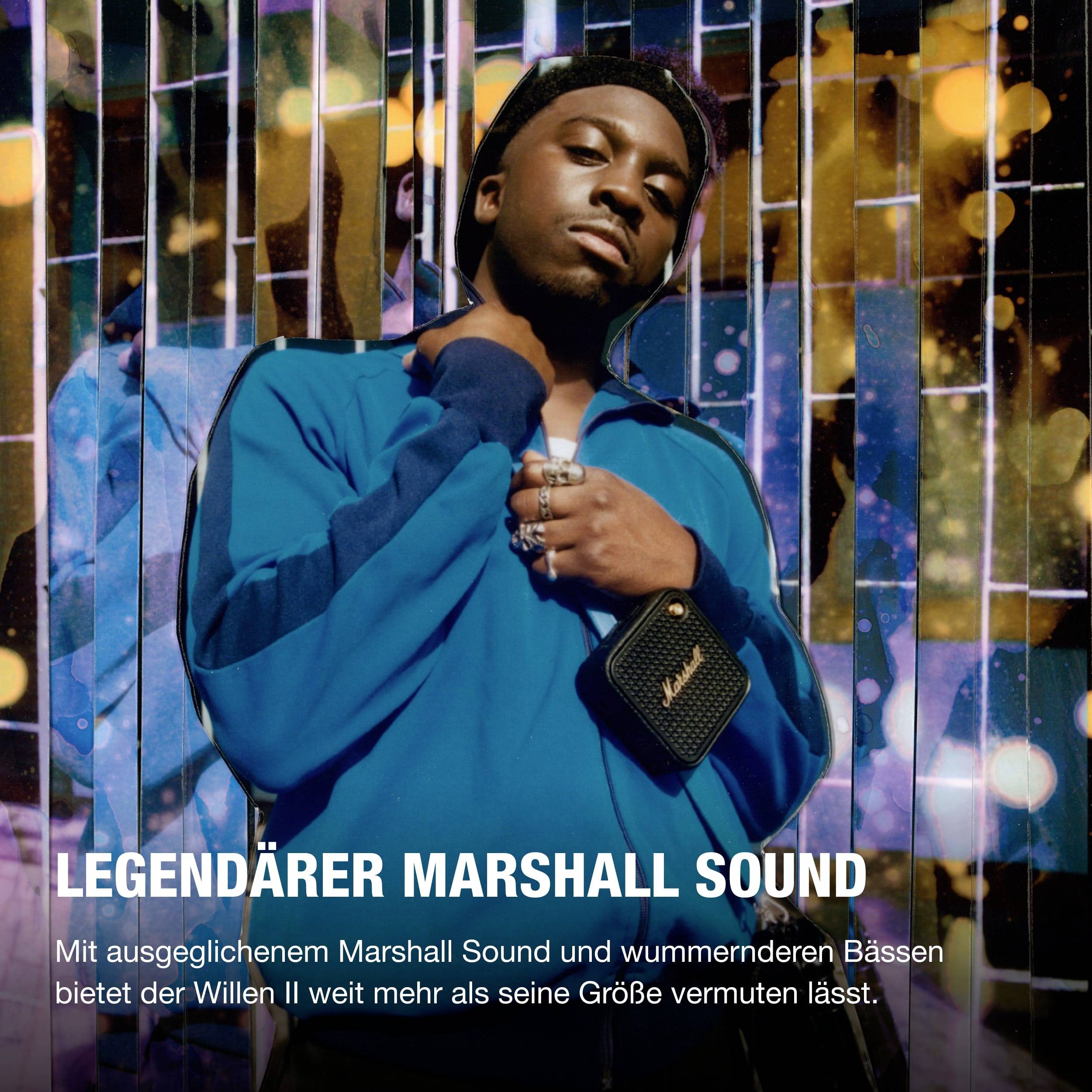 En mand i en blå jakke holder en Marshall-boks foran en farverig, lysende baggrund. Teksten beskriver Marshall-lyden.