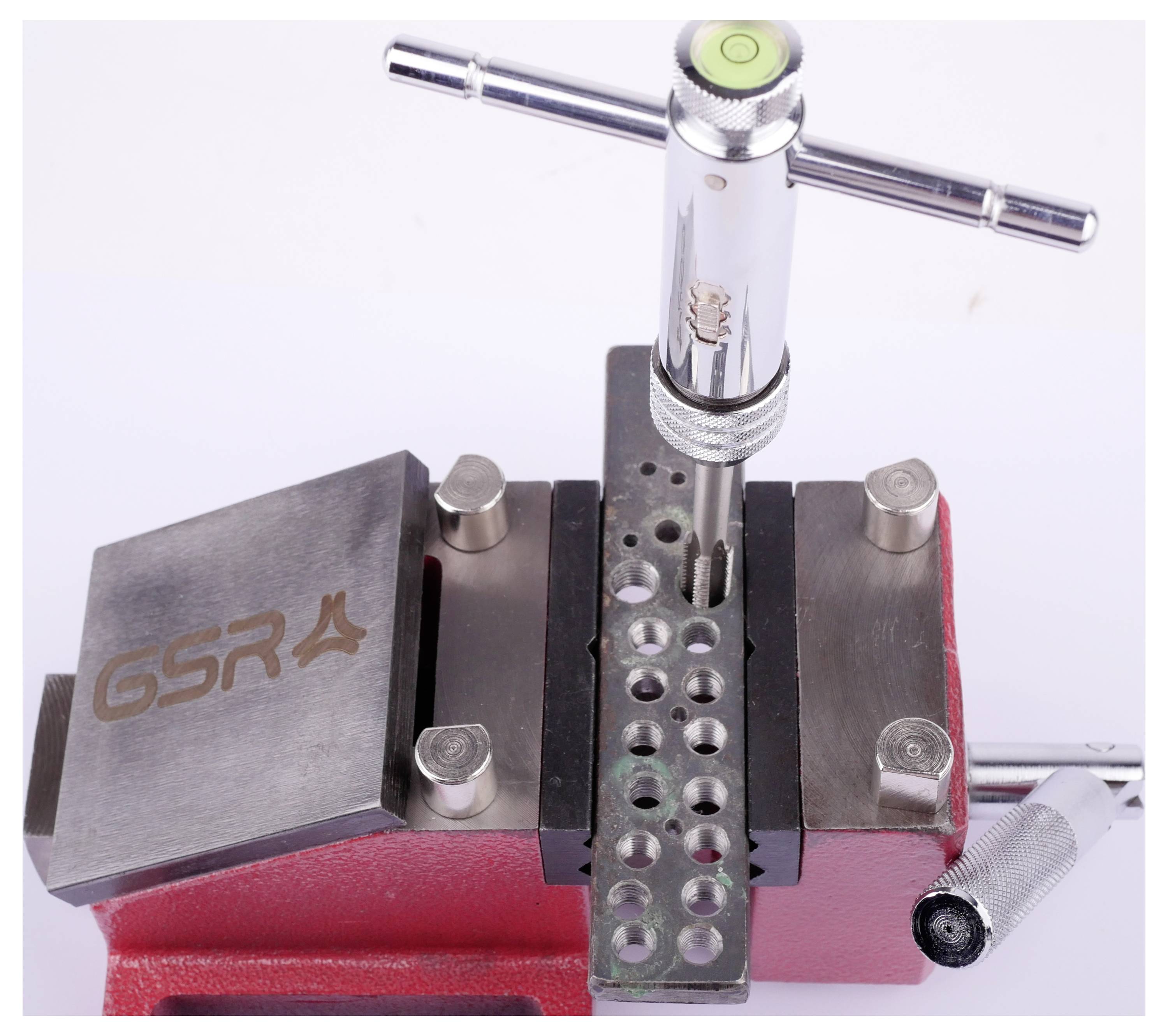 En metalinstrumentholder med en fastspændt stang. Påskrift: 'GSR'. En vandniveauboble på instrumentets overside.
