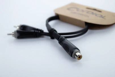 En kabeladapter med to røde og hvide RCA-stik på den ene side og et enkelt hunstik til RCA på den anden side.
