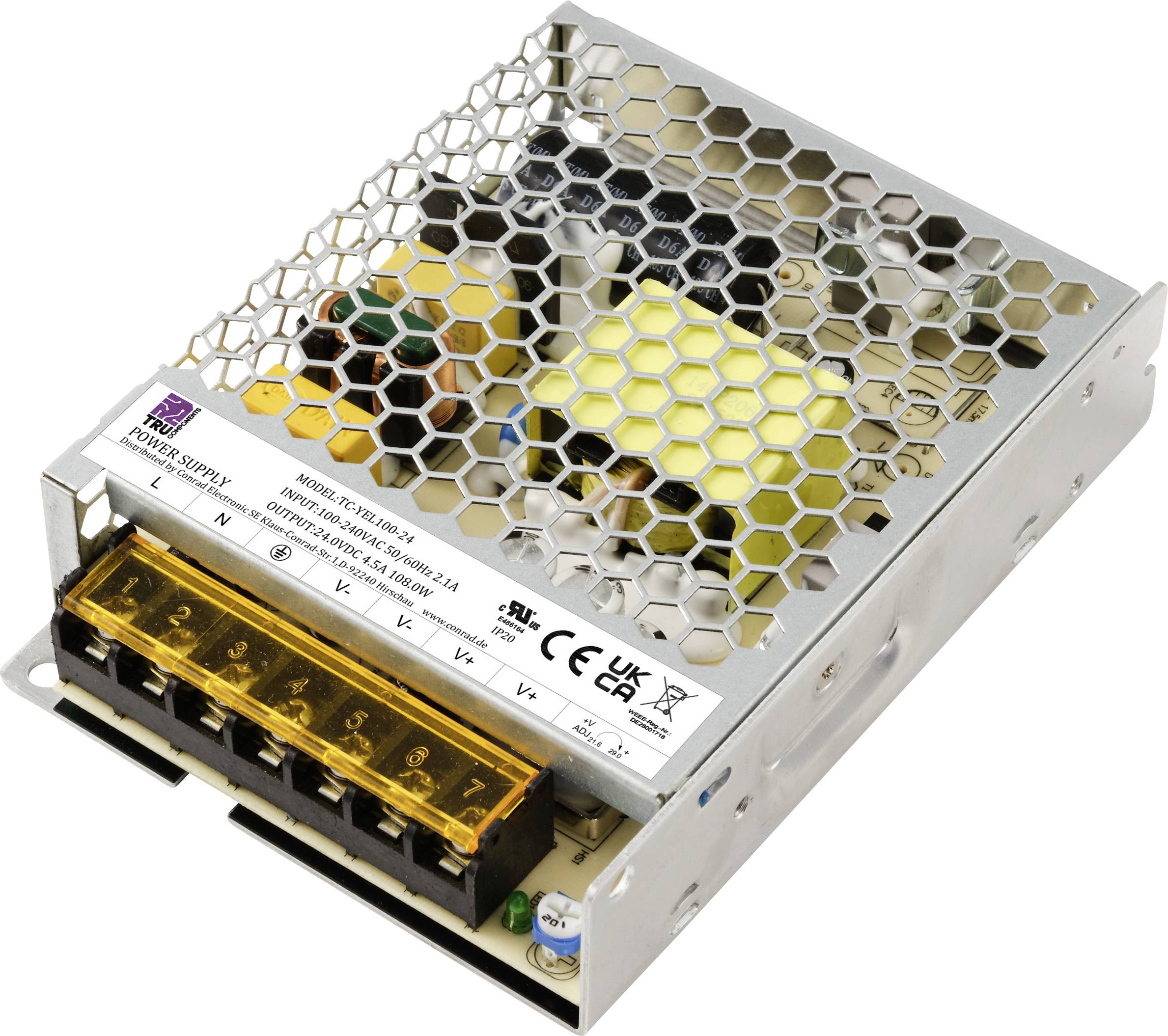 Et sølvfarvet switch-strømforsyning med honeycomb-strukturdæksel og gul klemrække, forskellige elektroniske komponenter synlige.
