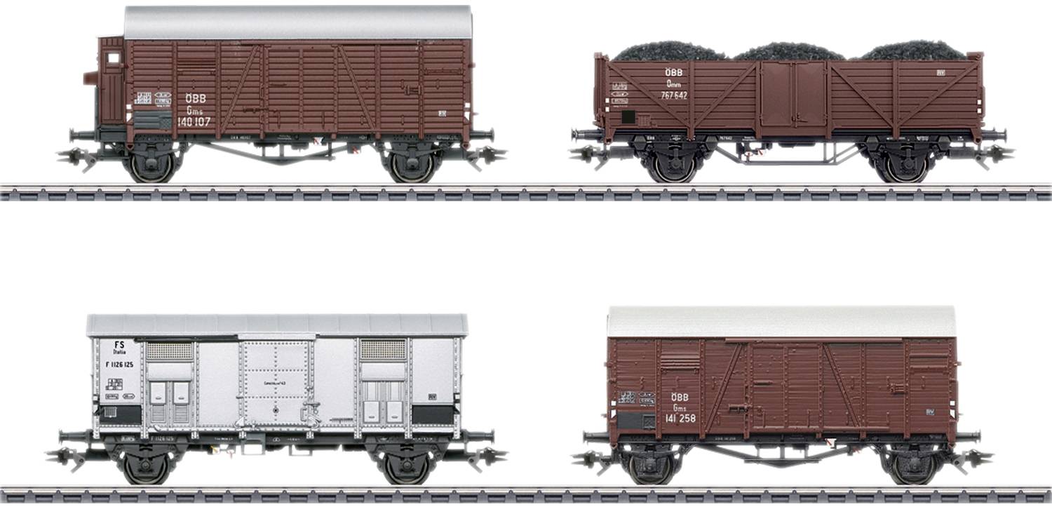 Fire forskellige godsvogne til modeljernbane på skinner, hver med forskellige designs og farver, til fremvisning af variationer.
