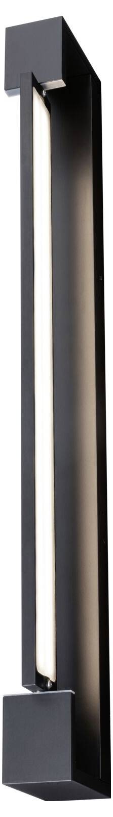 En smal, sort væglampe med minimalistisk design, der er monteret vertikalt. Den udsender indadrettet lys.
