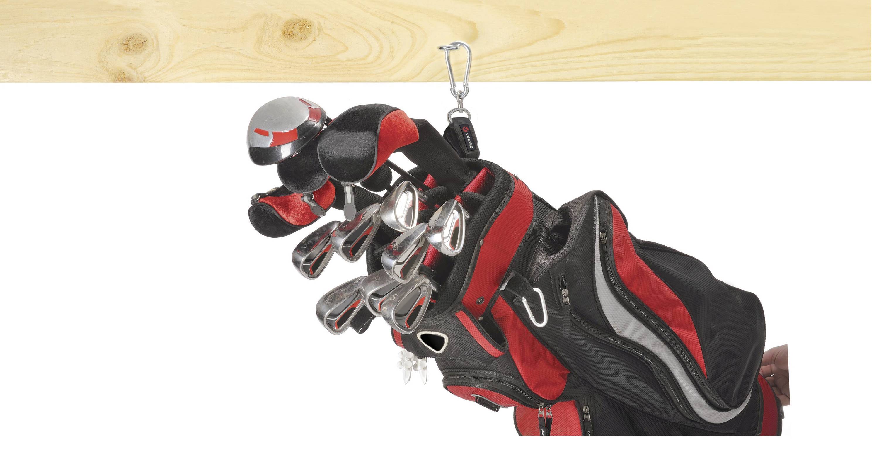En golftaske med flere køller hænger på en krog. Tasken har røde og sorte detaljer og er halvt synlig.