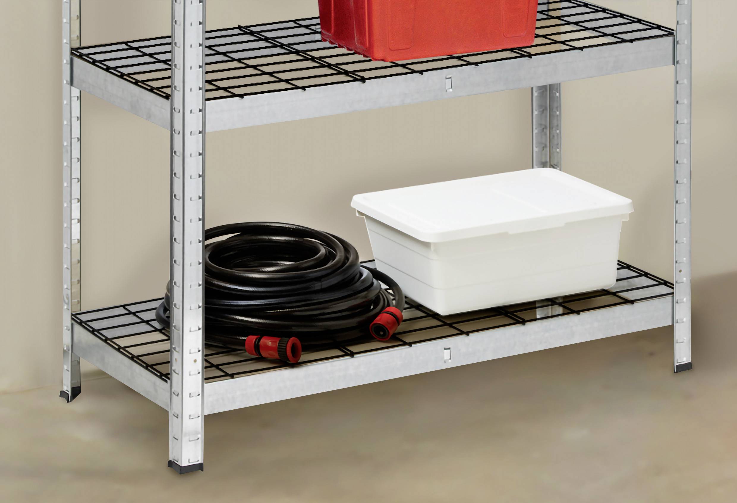 Et metalreol med tre hylder. På den nederste hylde ligger en oprullet sort slange og en hvid plastboks.