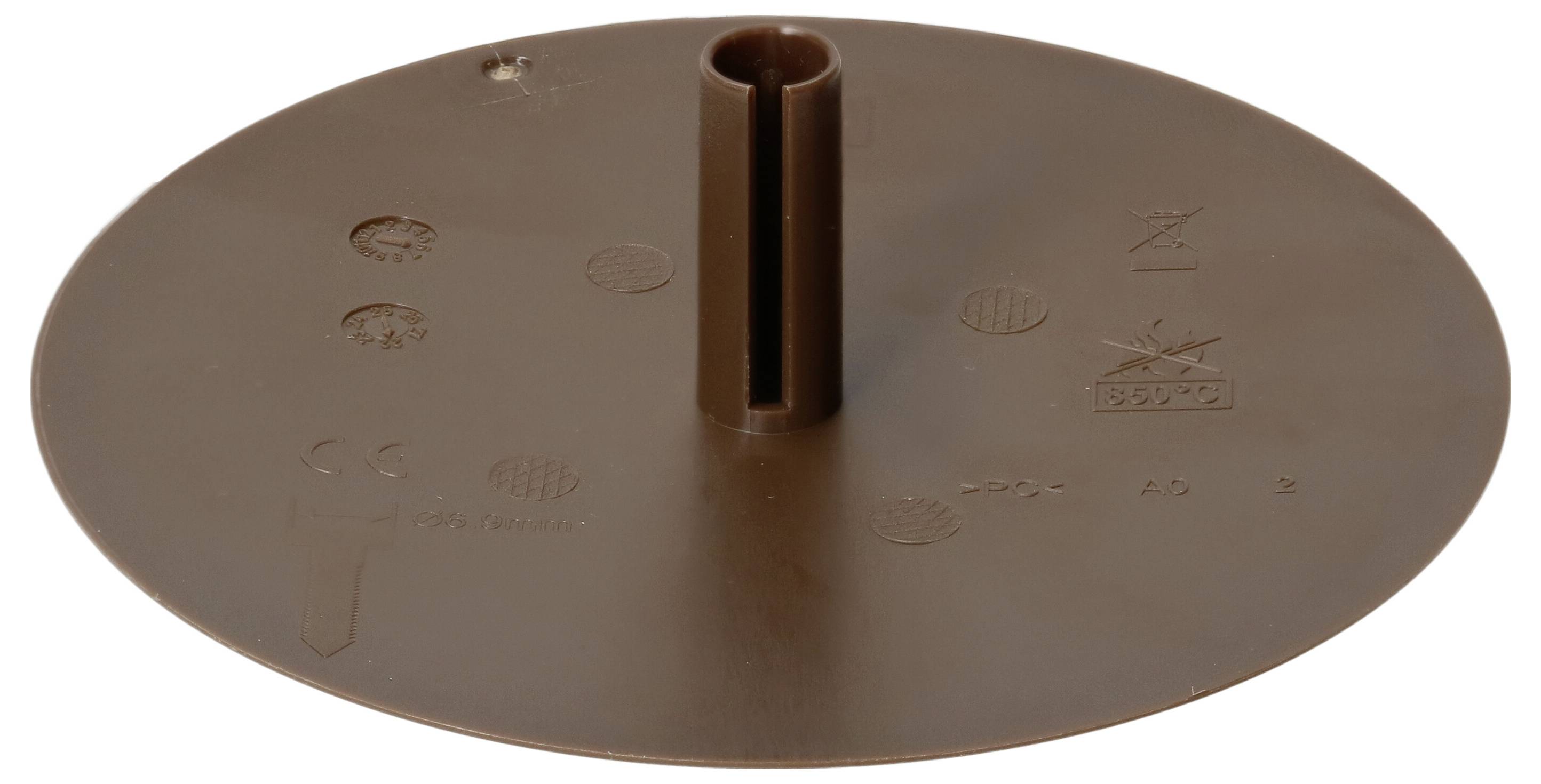 Brun, rund plastikbase med en lodret tap i midten og prægninger. Kan muligvis bruges som fod eller holder.