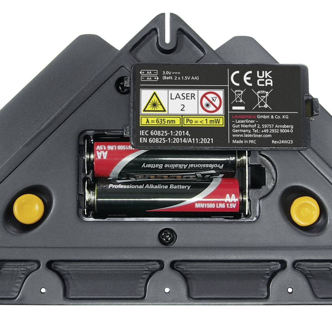 Batterirummet i en laserenheds, udstyret med to AA-batterier. Sikkerheds- og tekniske skilte er synlige.