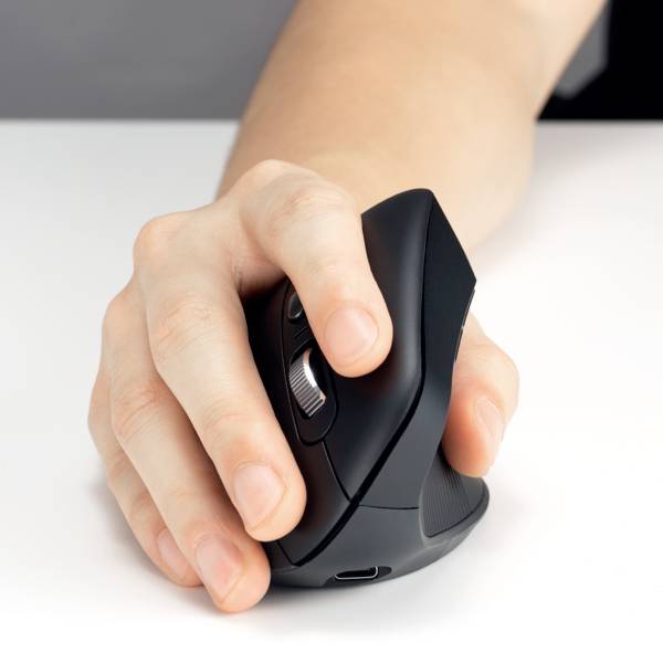 En hånd holder en ergonomisk, sort computermuse. Fokus er på håndens placering og musens design.