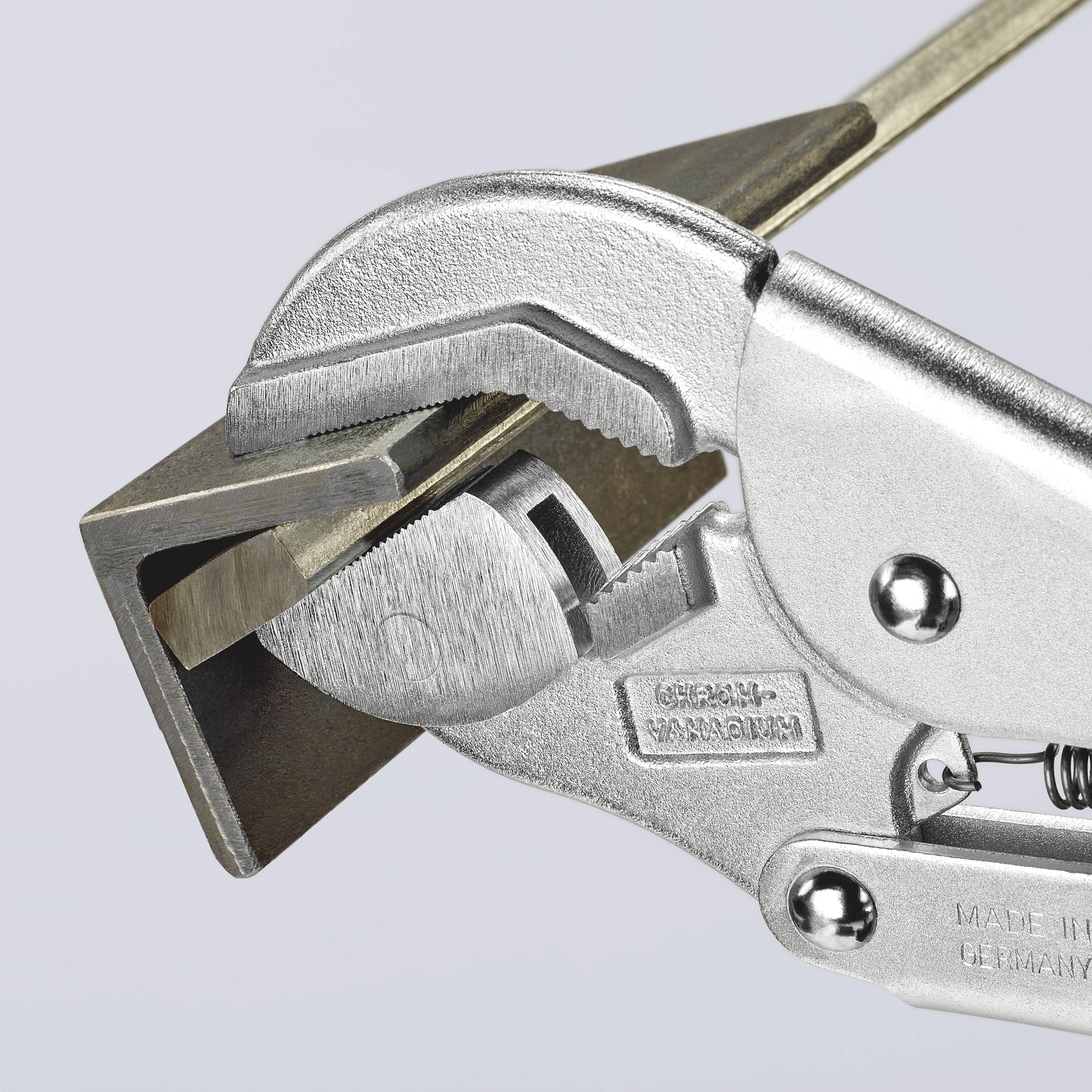En justerbar skruenøgle holder en trekantet metalprofil, som vises i åben tilstand.