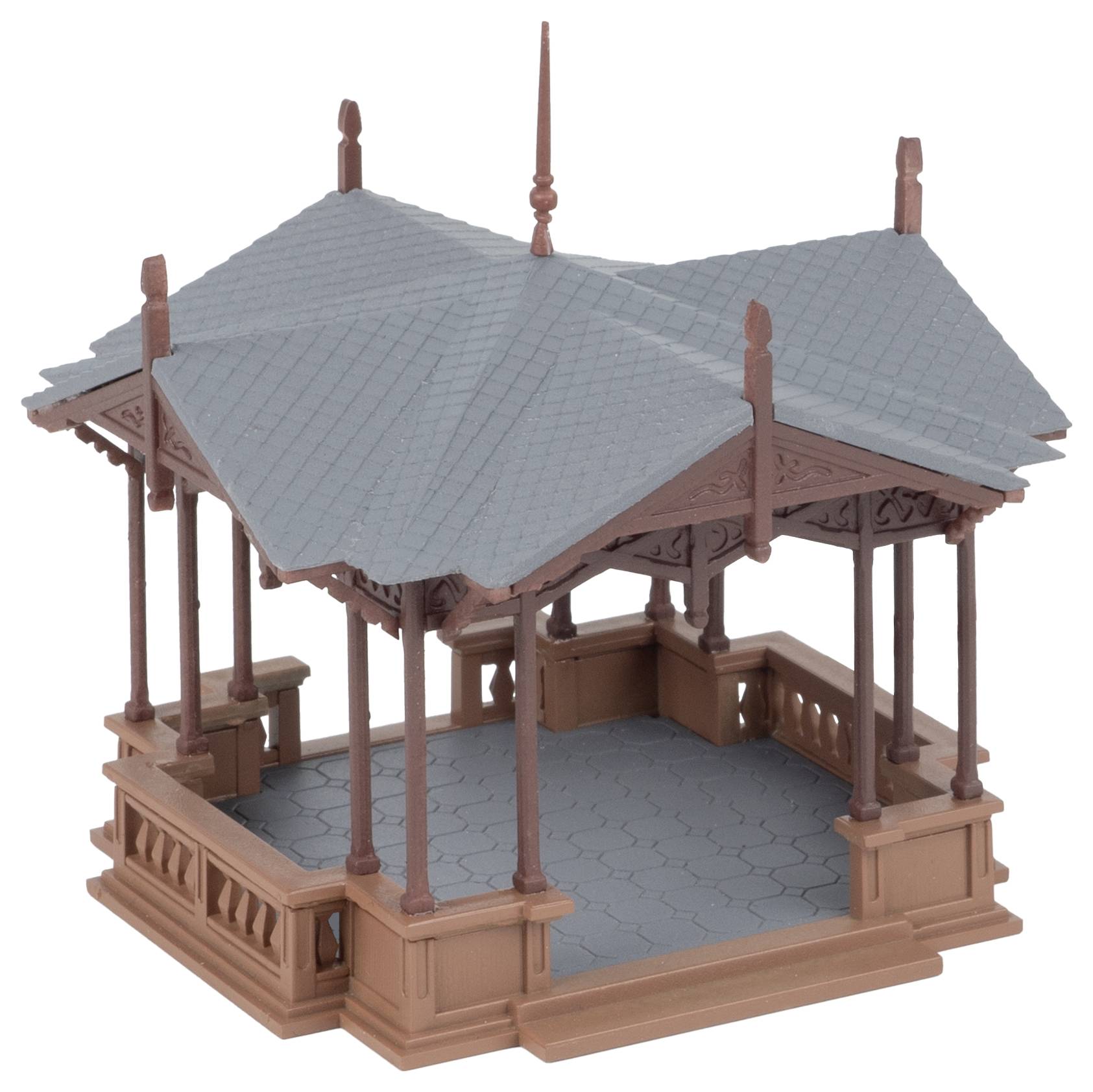 En brun modelpavilion i victoriansk stil med et gråt tag og dekorative detaljer står på en flisebelagt platform.