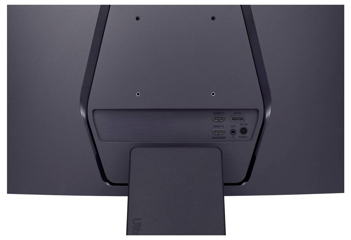Bagset af en mørkegrå computerskærm, der viser HDMI- og USB-porte tæt ved standens tilslutningspunkt.