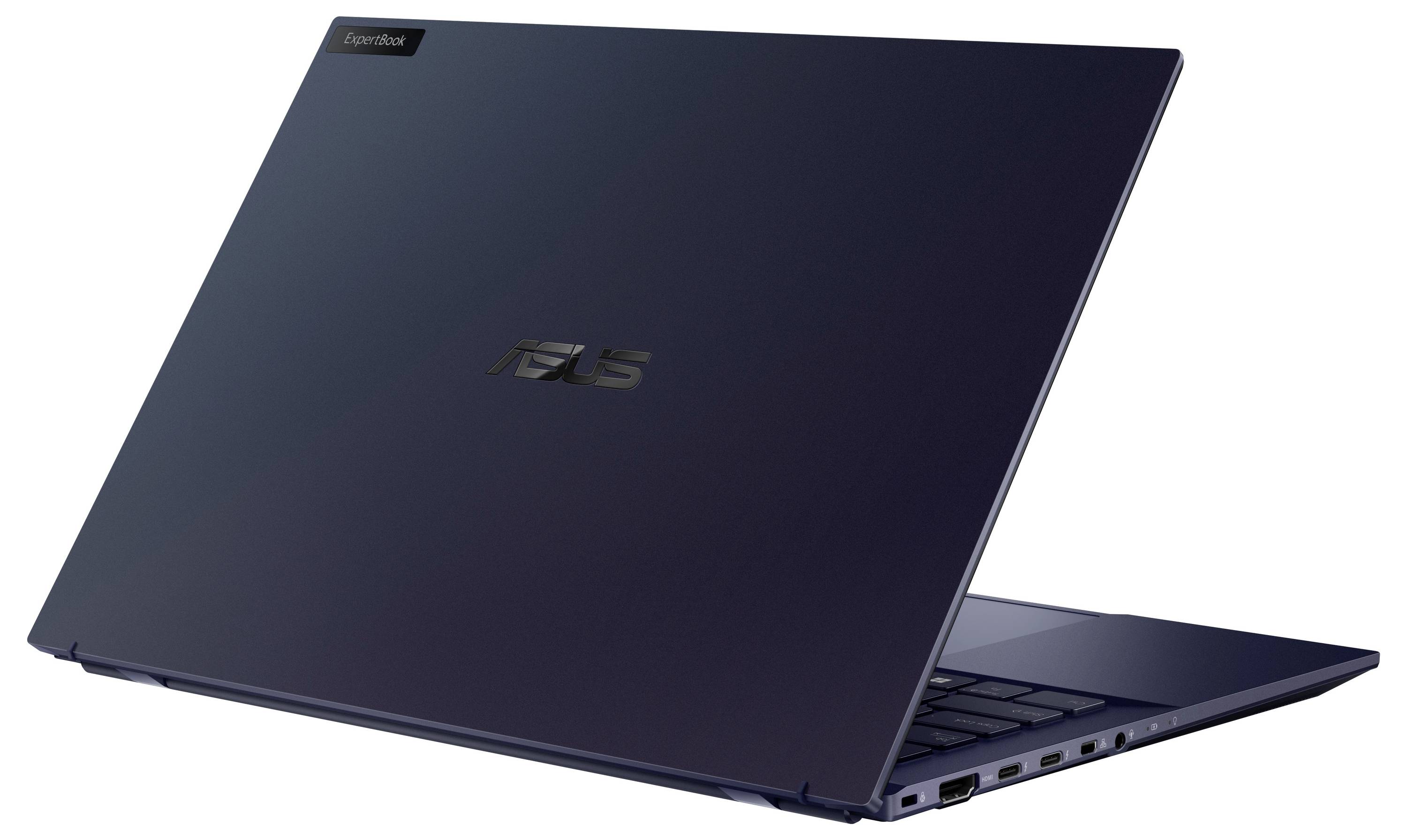 En elegant marineblå bærbar computer med flere porte på siden og et reflekterende logo på låget, sat op mod en enkel hvid baggrund.