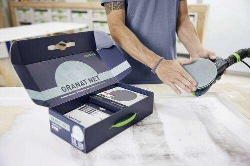 En person, der sliber en overflade med et sliberedskab, ved siden af en åben æske mærket 'Granat Net'.