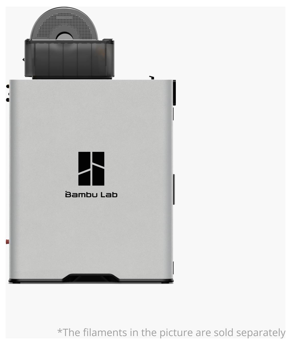 En 3D-printer fra Bambu Lab med en filamentholder øverst. Enheden er sølvfarvet med brandlogoet centreret på forsiden. Teksten nedenunder bemærker, at filamenter sælges separat.