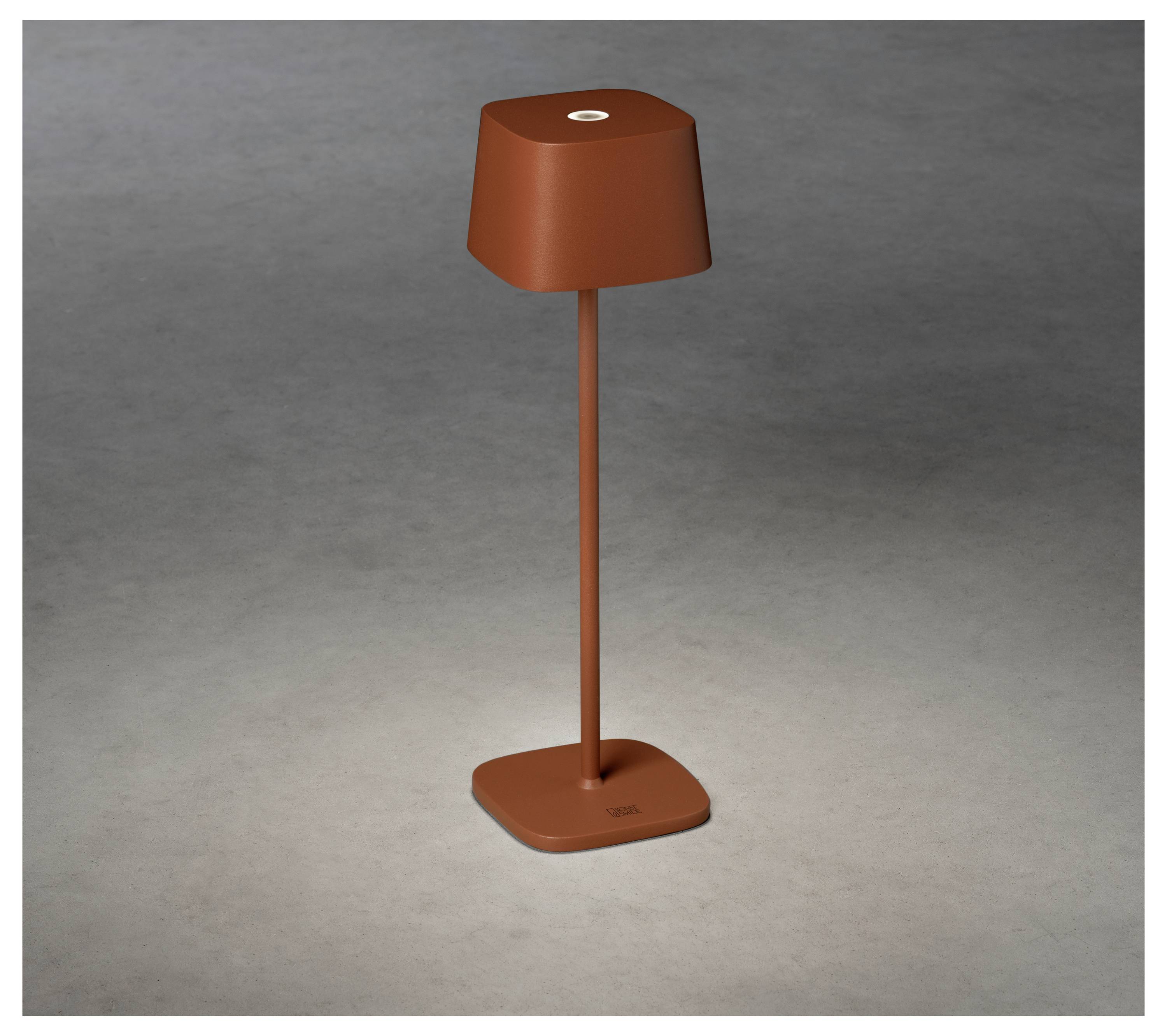 Et moderne, brunt, minimalistisk bordlampe med en slank stang og en firkantet base, placeret på en enkel grå overflade.