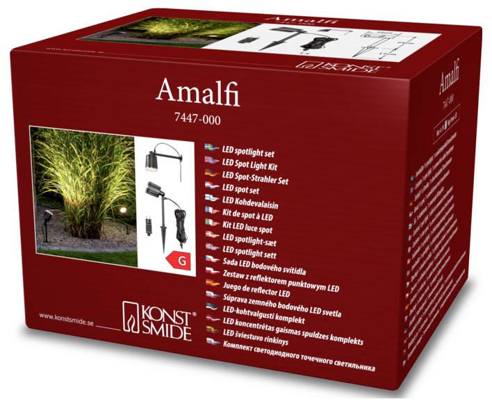 Konst Smide Amalfi LED-spotlightsæt emballage der viser billeder af udendørs belysningsopsætning. Modelnummer 7447-000 vist på æsken.