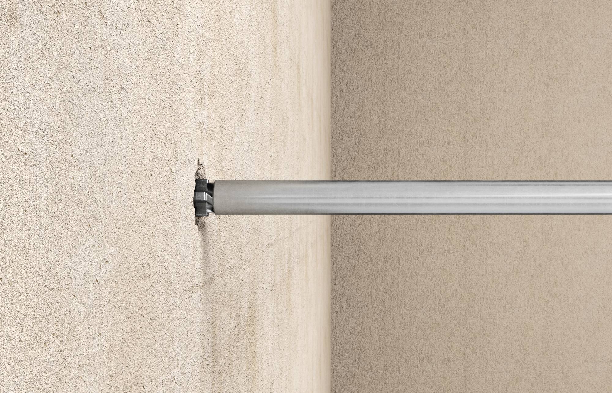 Metalstang eller rør, der stikker vandret ud fra en væg, og ender tæt på billedets højre kant.